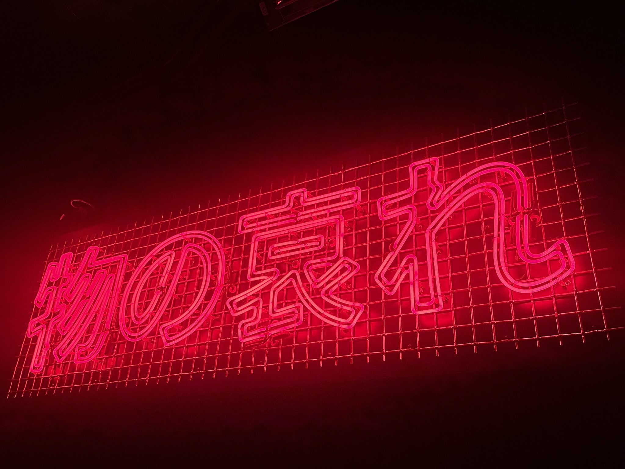 A red neon sign that says 'Mono no aware' meaning 'Pathos