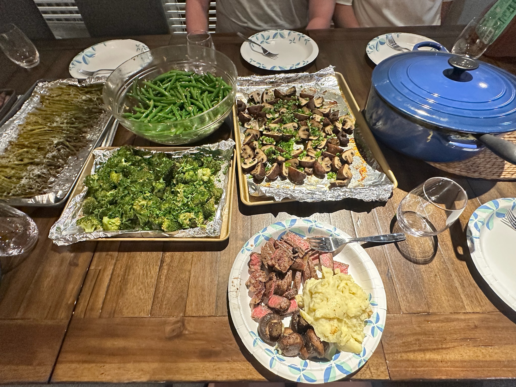 Family dinner of steak, mashed potatoes, aspearagus, broccoli, mushrooms, green beans